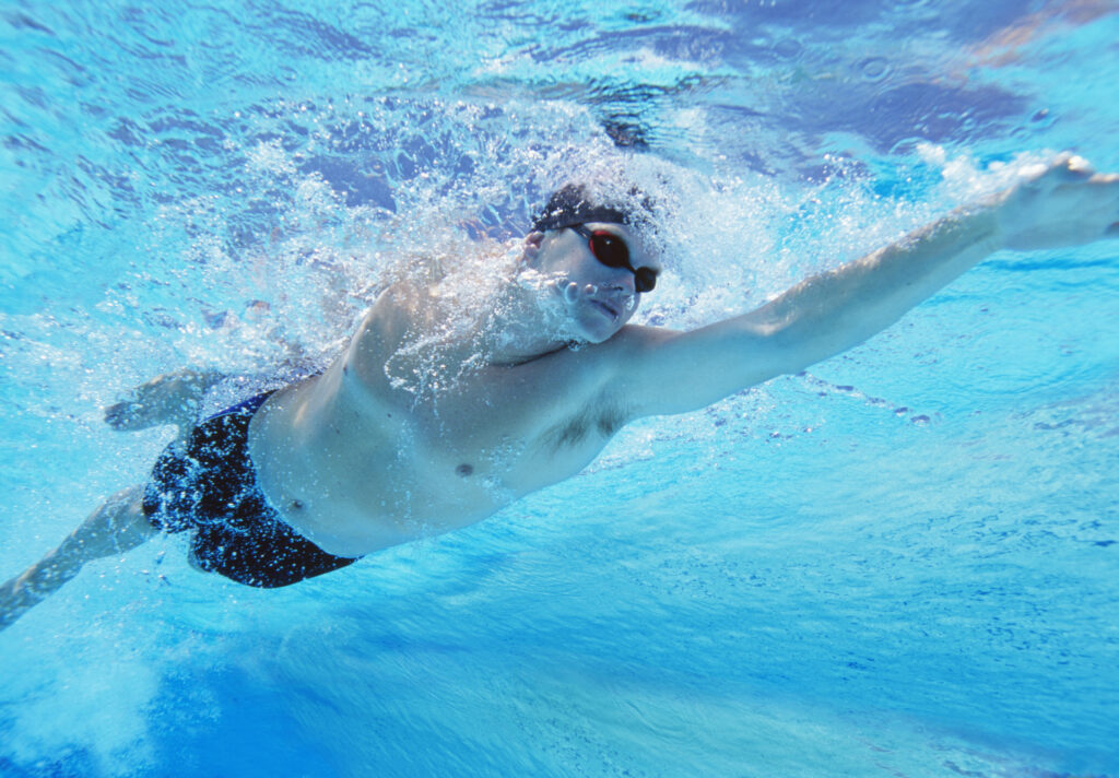 Underwater shot of professional male athlete swimming in pool
